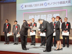 President and Representative Director Yuji Kaneko receiving the plaque