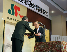 Executive Director Kenichi Osako receives a plaque