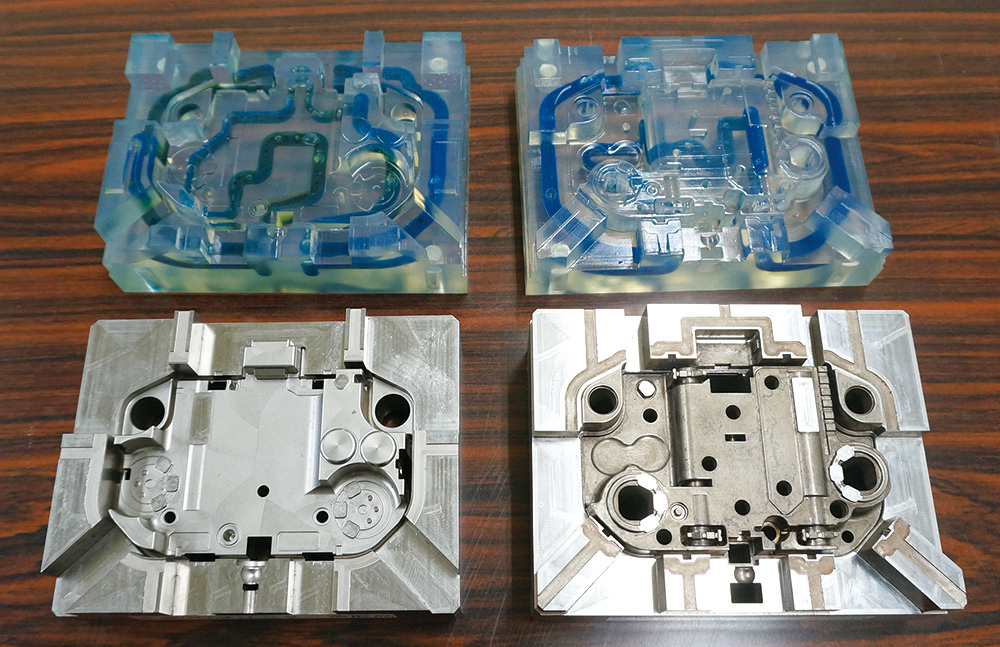 Mold (bottom) and its model (top) of the motor housing containing the conformal cooling water pipe.
								Cooling efficiency increased and deformation of printed products were suppressed.